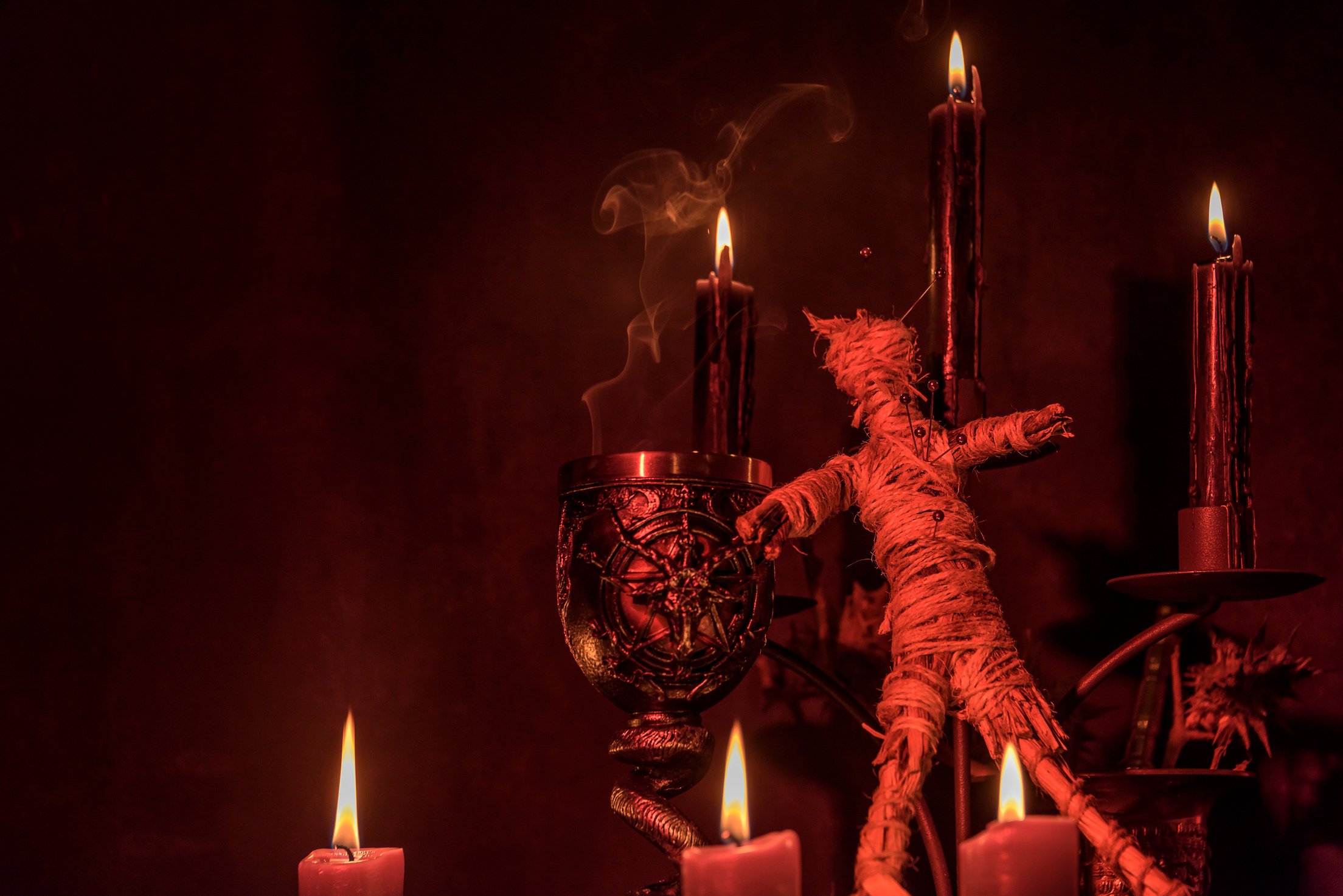 Voodoo Doll on a Wooden Background with Dramatic Lighting.